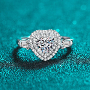 Diamond ring with heart-shaped center on a teal background