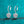 Heart-shaped silver earrings with clear gemstones on a teal background