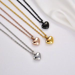 Four heart-shaped pendants on chains against a white background