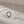Two necklaces with interlocking rings on a beige background
