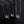 Three necklaces with origami crane pendants on a black background