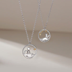 Two silver necklaces with the little prince and fox pendants on a light background