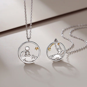 Two silver necklaces with the little prince and fox pendants on a light background