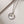 Silver necklace with the little prince pendant on a light background