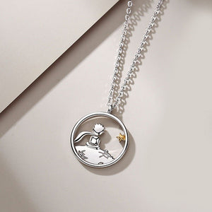 Silver necklace with the little prince pendant on a light background