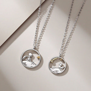 Two silver necklaces with the little prince and fox pendants on a light background