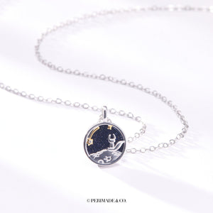 A sterling silver necklace with a round pendant featuring a fox and a star on a moonlit background. The pendant is gold plated, and the necklace is adjustable.