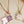 Two openable photo lock pendants on gold and rose gold chains against a beige background