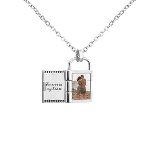 Silver openable photo lock pendant on a chain on a white background