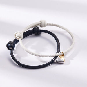 Two braided bracelets, one black and one white, on a light gray background.