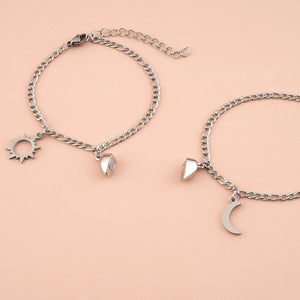 Two silver bracelets with charms on a peach background