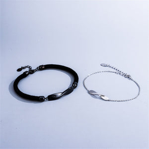 Black and silver bracelets on a light gray background