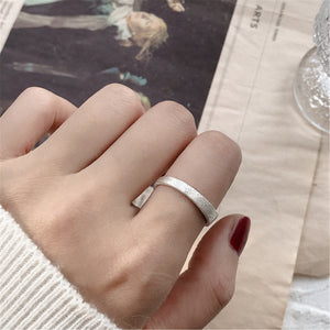 Silver ring on a finger with a blurred background