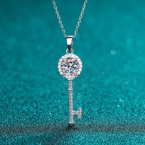 Silver key-shaped pendant necklace with a diamond on a teal background