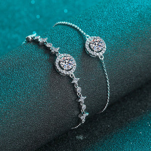 Silver bracelet with star and moon designs on a dark teal background