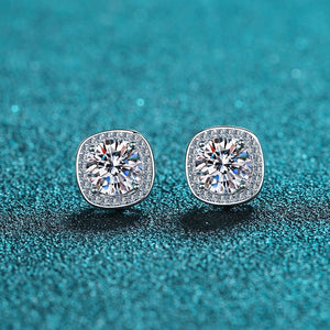 Pair of diamond earrings on a teal glittery background