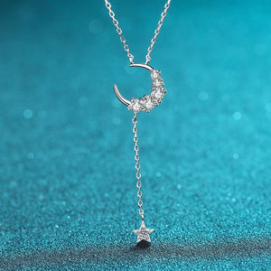 Silver necklace with a crescent moon and star pendant on a blue background