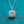 Diamond necklace with pink gemstone on a blue glittery background
