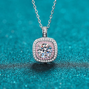 Diamond necklace with pink gemstone on a blue glittery background