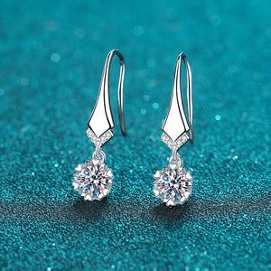 Silver earrings with clear gemstones on a blue glittery background