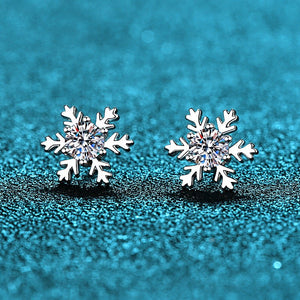 Silver snowflake earrings on a blue textured background
