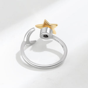 Silver spinner ring with a gold star and engraved text on a light gray background