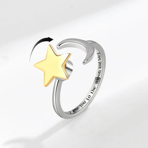 Silver spinner ring with a gold star and engraved text on a light gray background