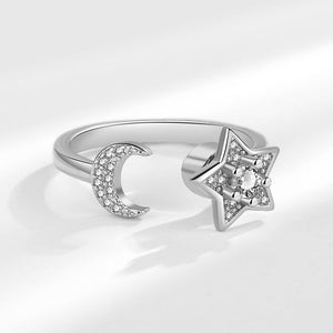 Silver spinner ring with star and moon design on a white background