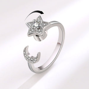 Silver spinner ring with star and moon design on a white background