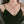 A person wearing a black top and silver lariat necklace with a moon and star charm.