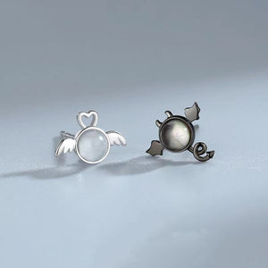 Pair of silver and bronze earrings on a light gray background