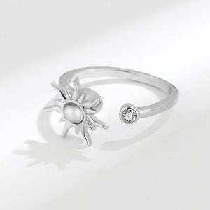 A silver band ring with a sun motif and a small cubic zirconia stone, displayed against a white background.