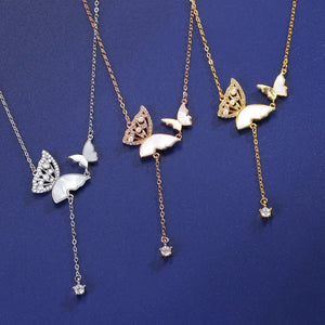 Three butterfly-themed necklaces on a blue background