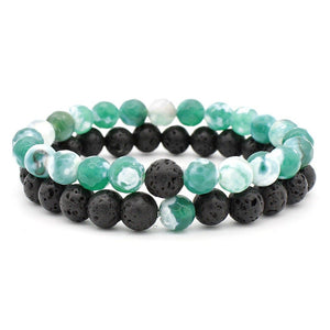 Set of three beaded bracelets with green, black, and white beads on a white background