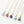 Five gold necklaces with colorful stone pendants on a white background
