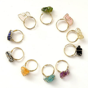 Gold rings with various colored gemstones on a white background