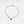 Gold bracelet with leaf and gemstone charm on a light gray background