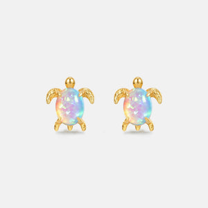 Opal sea turtle earrings with gold accents on a light gray background