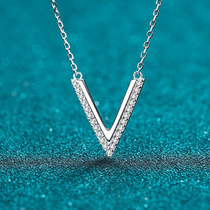 Silver 'V' necklace with diamonds on a teal background