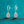 Pair of silver teardrop earrings on a teal glitter background