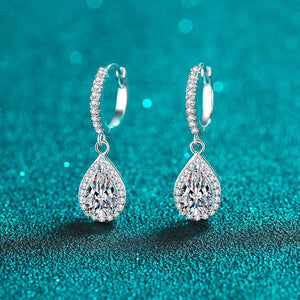 Pair of silver teardrop earrings on a teal glitter background