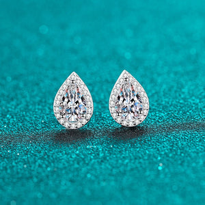 Teardrop-shaped diamond earrings on a teal background