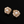Pair of floral earrings with pearls and gold accents on a black background