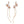 A woman wearing a white dress featuring long dangle drop earrings with gold plating, pearls, and leaf designs.