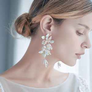 Close-up of a woman wearing elegant floral earrings with a blurred background