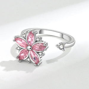 Silver ring with pink flower-shaped gemstones on a white background