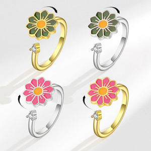 Four flower-shaped rings in gold and silver on a white background
