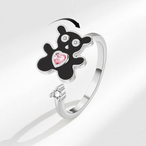 Silver ring with black bear-shaped design and pink gem on a white background