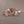 Two gold rings with gemstones on a gray background