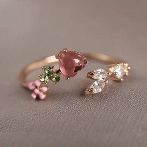 Two gold rings with gemstones on a gray background